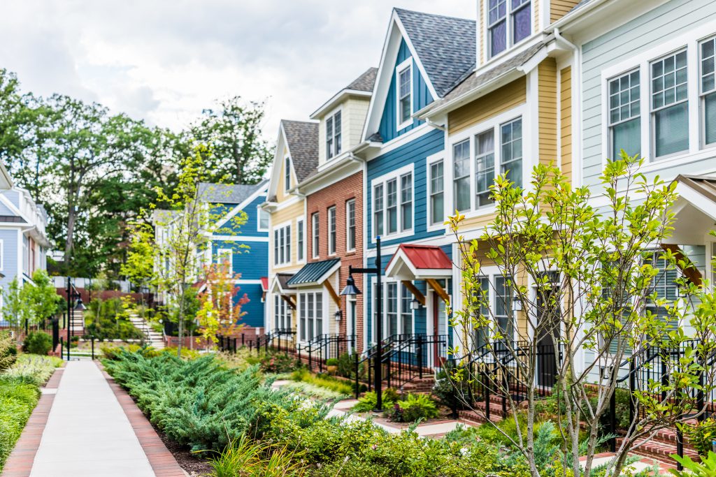 Row of colorful, red, yellow, blue, white, green painted residential townhouses, homes. They affect each other's appraisal value.